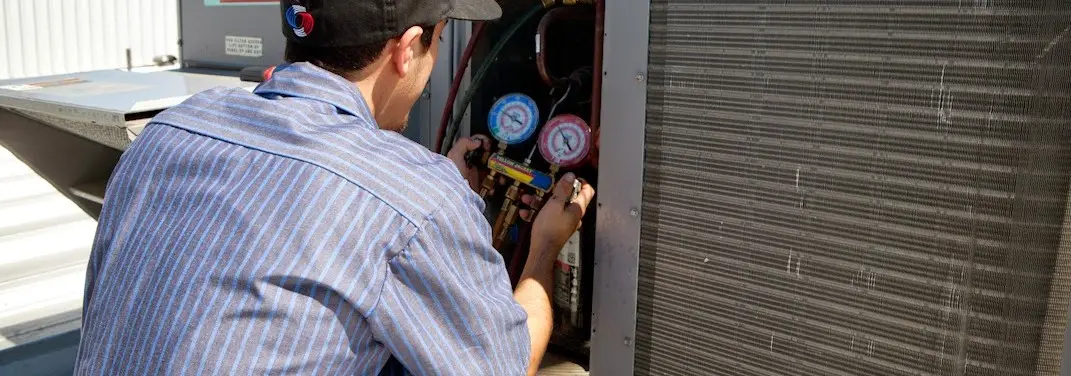 HVAC technician servicing a condenser unit in Waipio